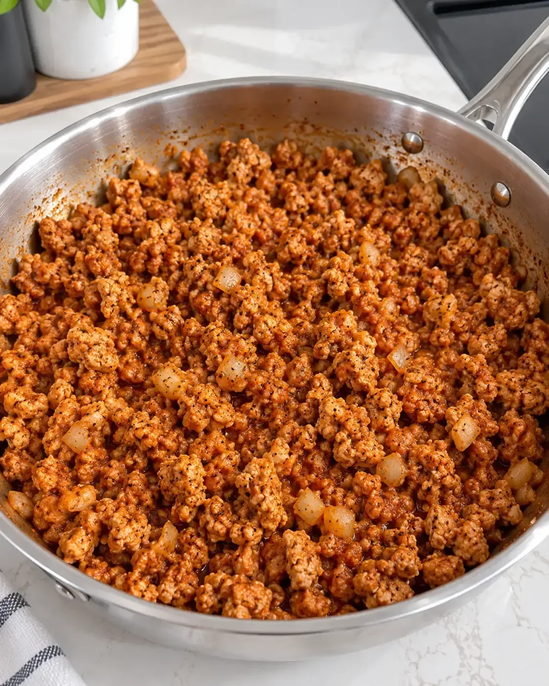 Cooked ground turkey crumbles mixed with onion, tomato paste, and seasonings in a skillet before adding cottage cheese.